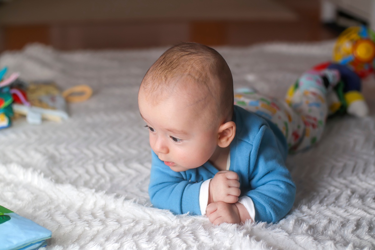 4months old and alert baby doing tummy time on a blanket